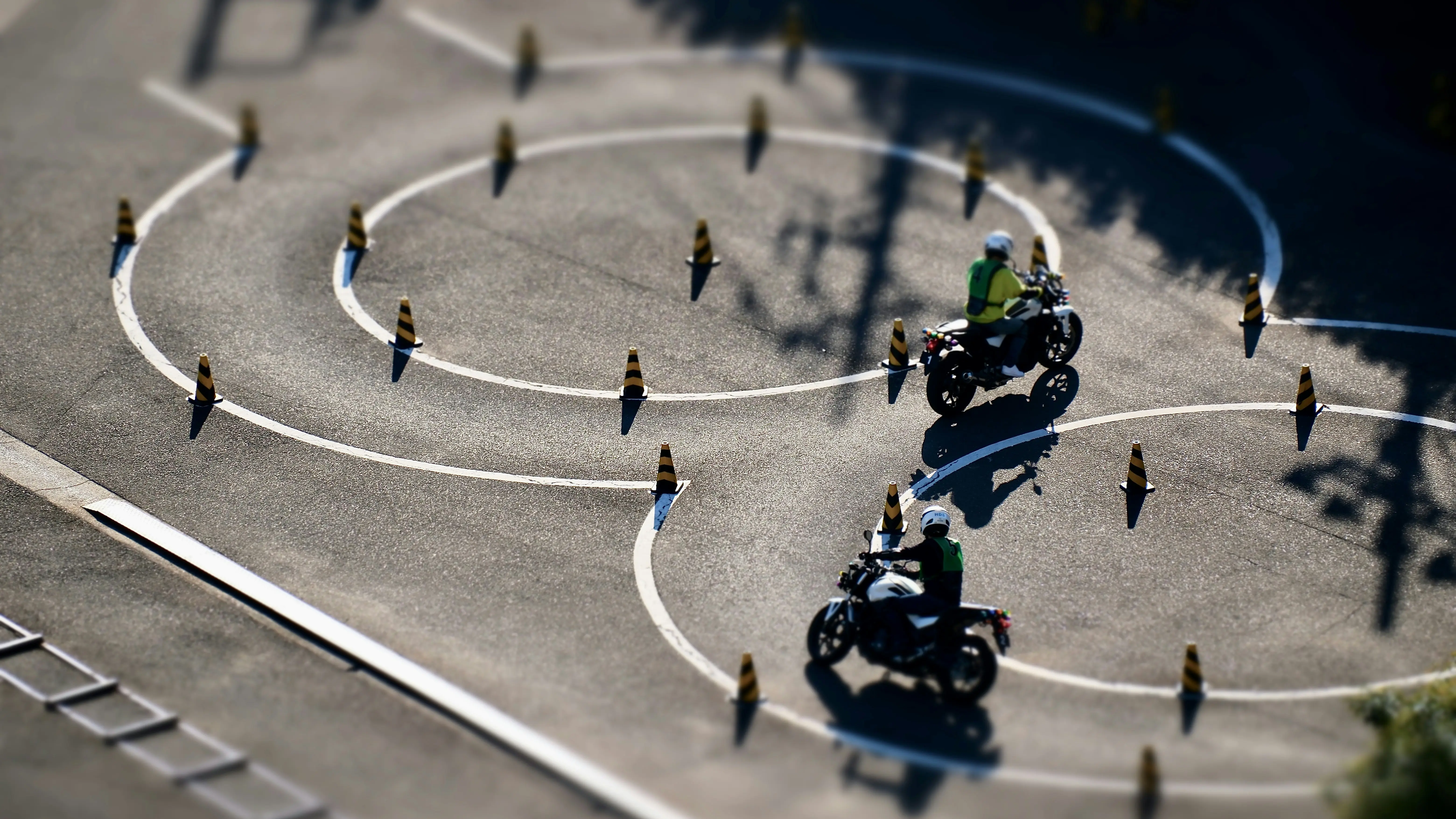Two riders practising between cones on the training course, seen from above